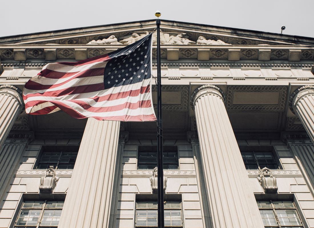 Bandera de Estados Unidos ondeando en la entrada de un edificio de gobierno
