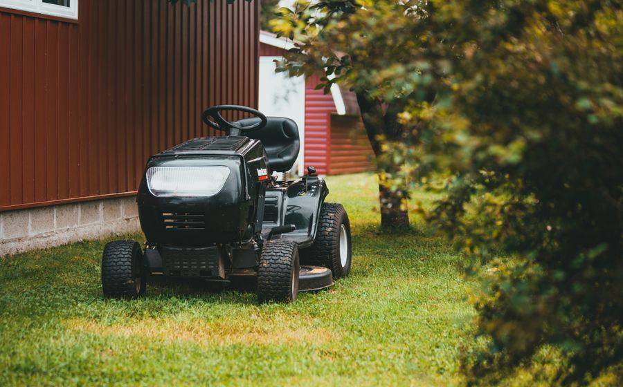 Ride-on lawn mower parked on a maintained lawn